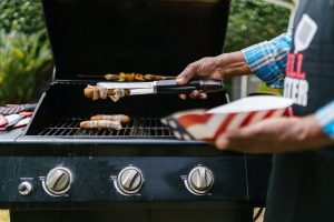 close up of a person grilling hotdogs