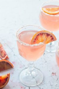 pink cocktail drinks with slices of red orange